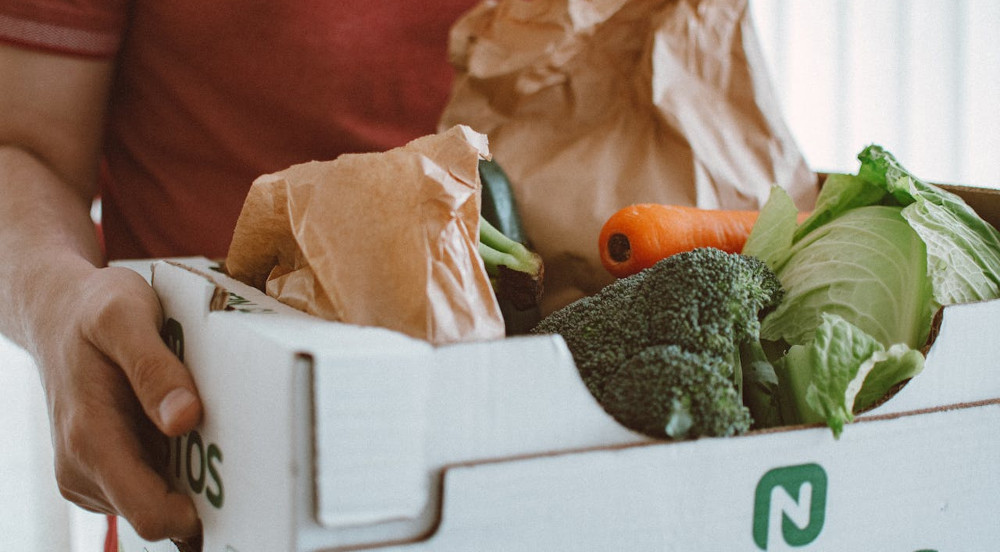 man carrying box of produce